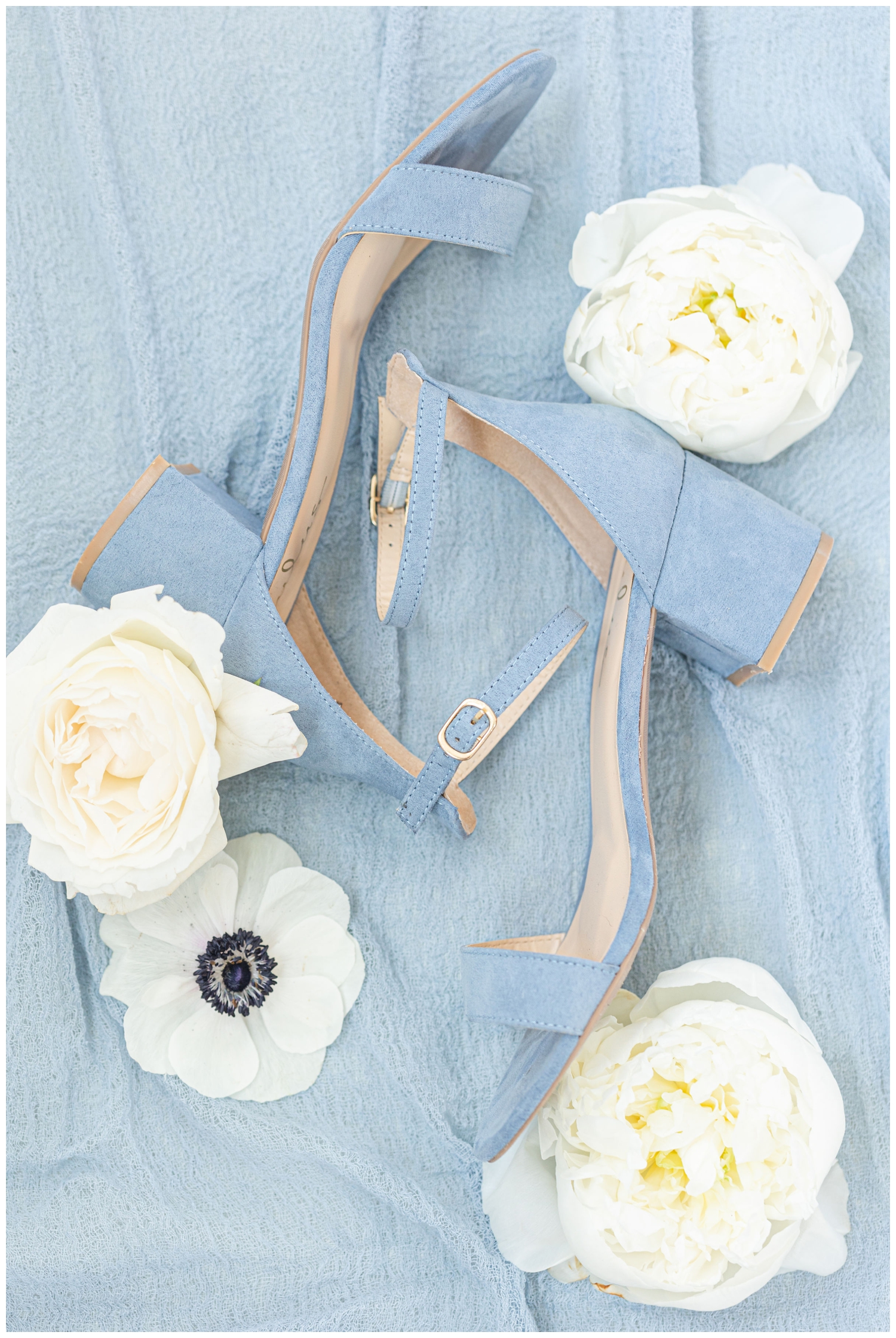 details shot of soft pale blue wedding heels with white roses