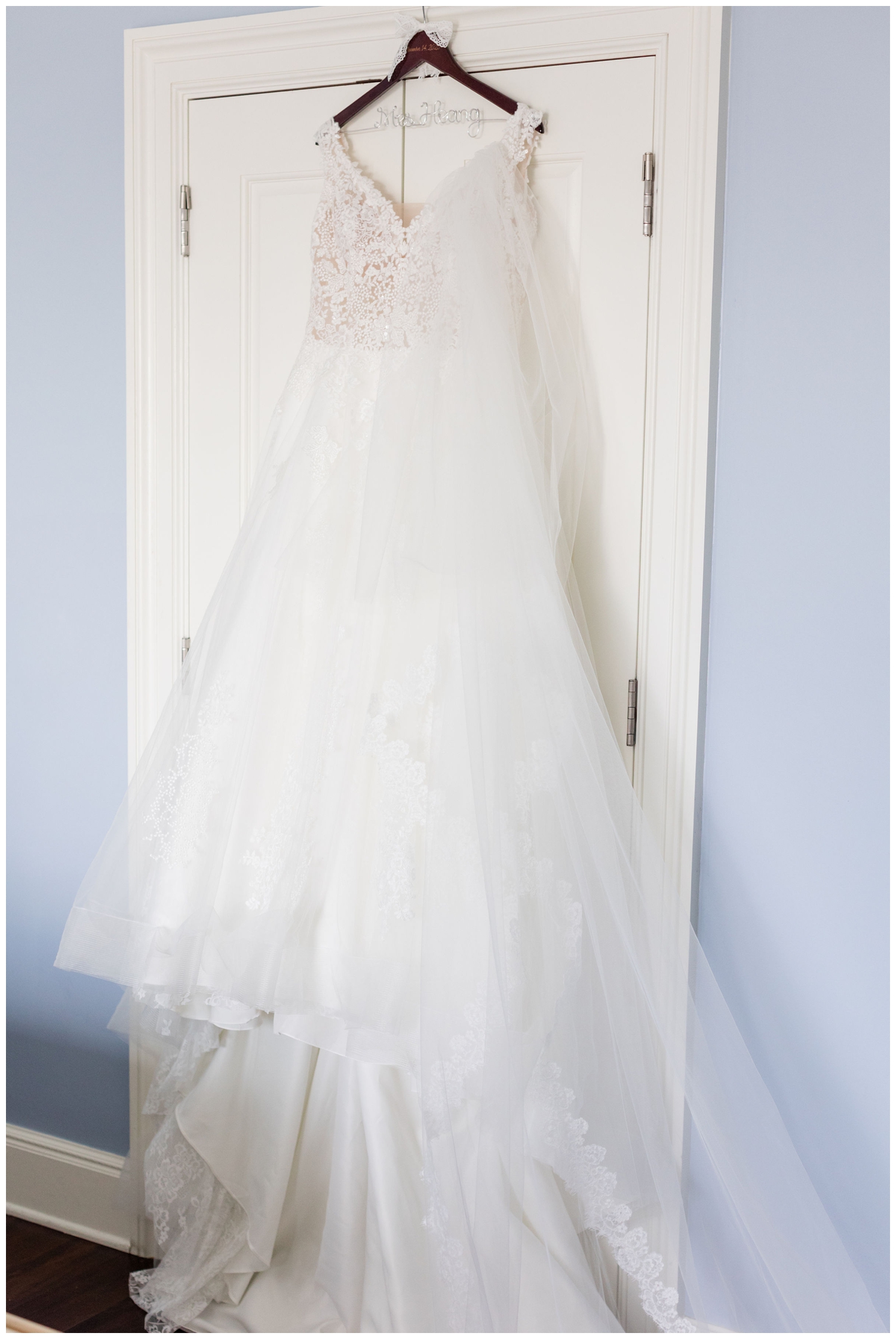 white wedding gown hanging on door