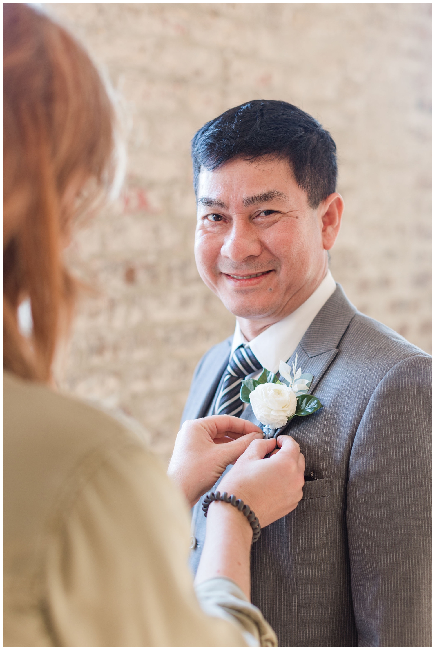 groom getting ready with boutonniere during Charleston micro wedding