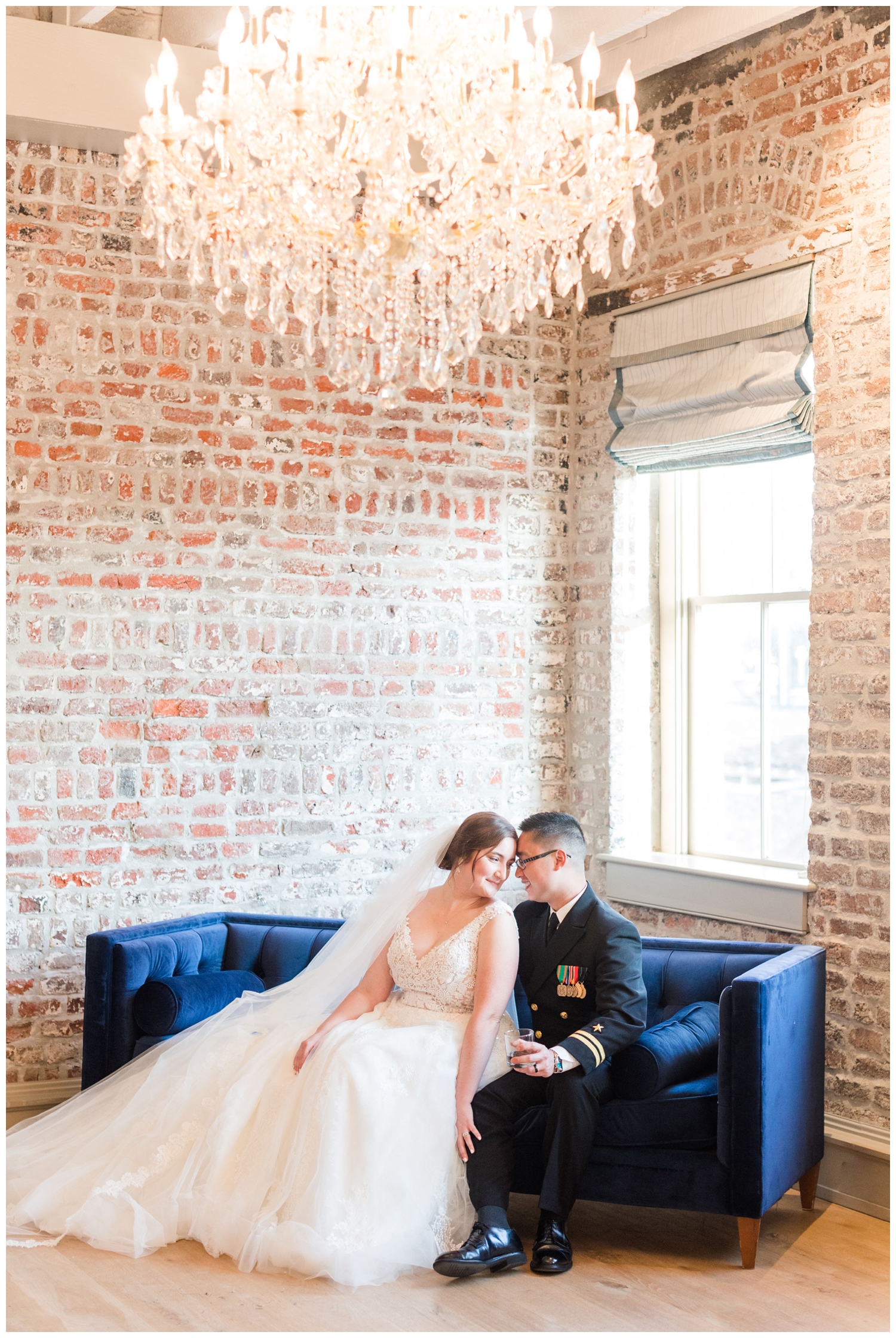 bride and groom wedding portrait sitting on blue couch inside Merchants Hall