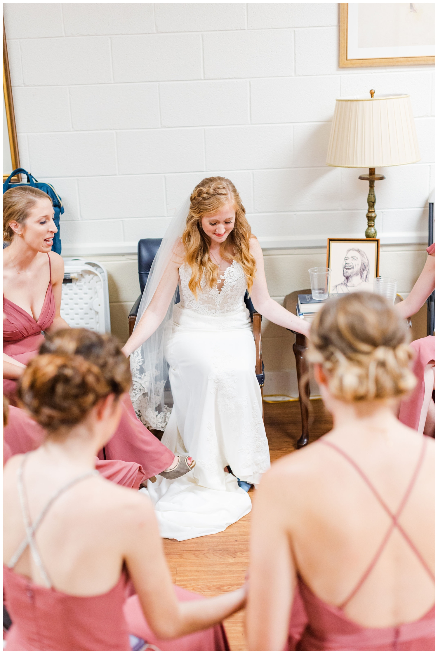 bride praying with bridesmaids before a colorful fall Charleston wedding ceremony at John Wesley United Methodist Church