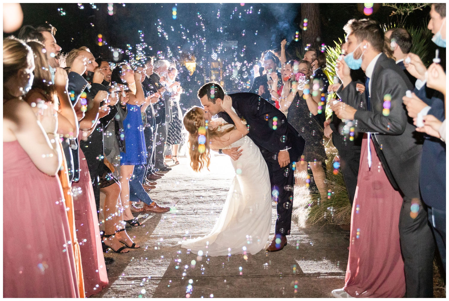 bride and groom kissing during wedding reception bubble exit