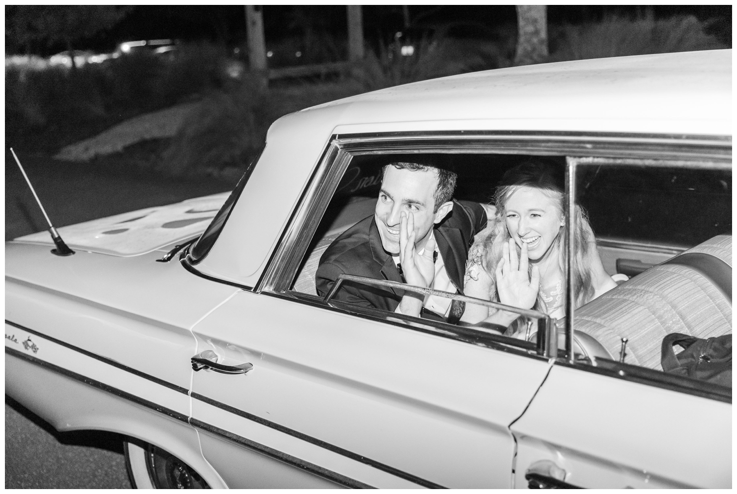 bride and groom waving goodbye in getaway car
