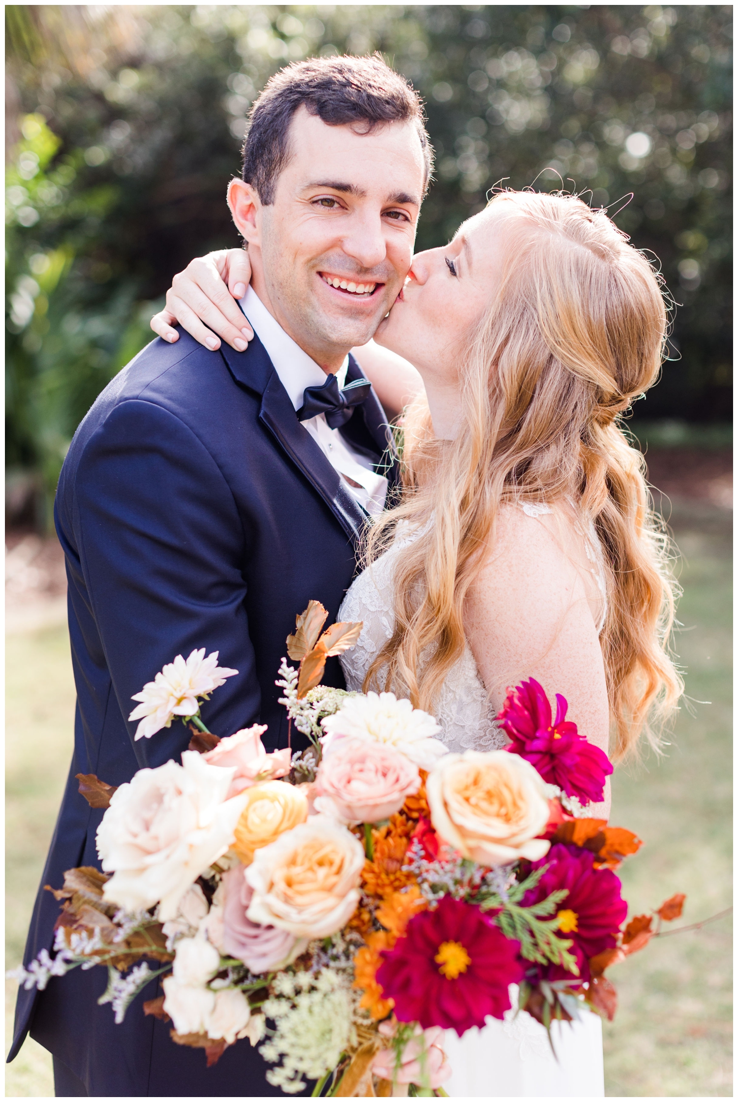 bride kissing groom during portraits for a colorful fall Charleston wedding