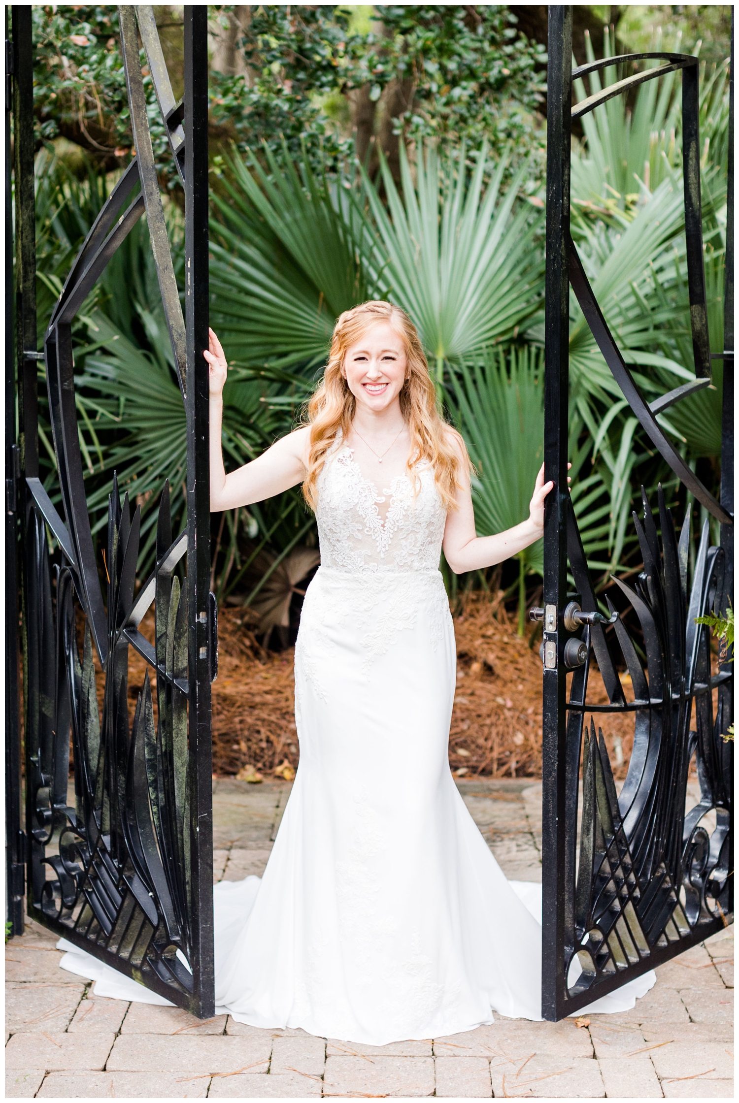 bride posing and holding iron wrought gate doors for a colorful fall Charleston wedding