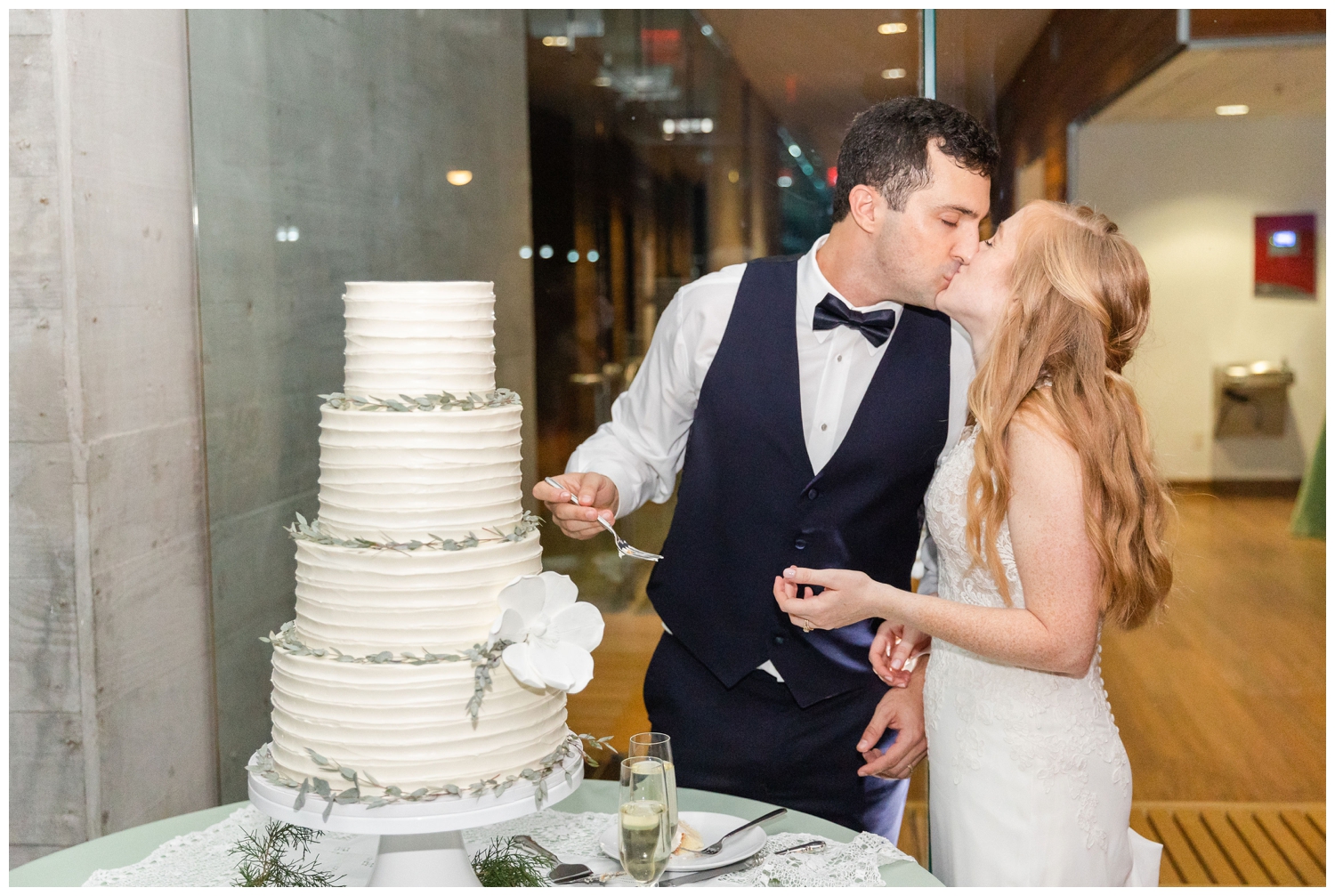 bride and groom kissing at cake cutting