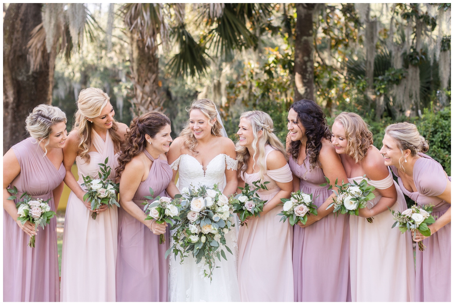 bride with bridesmaids outside under oak trees