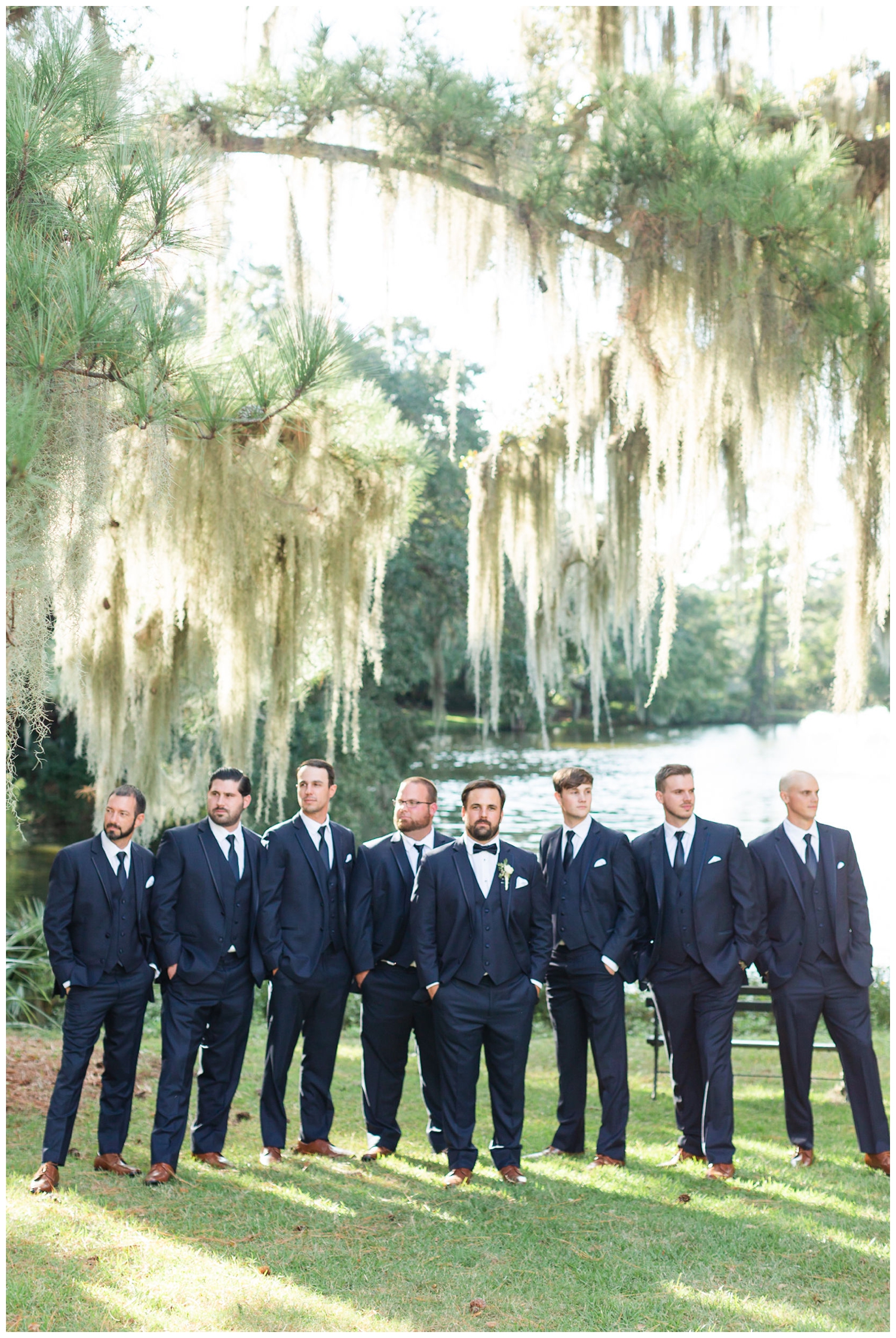groom and groomsmen standing under oak trees