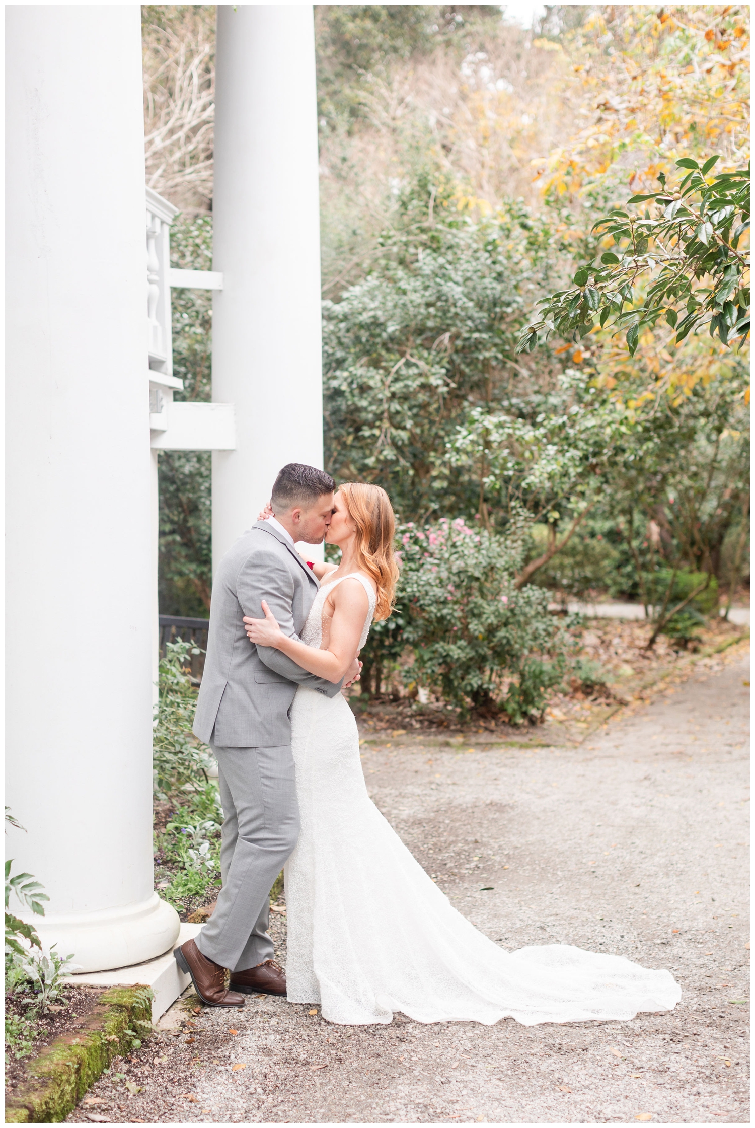 bride and groom kissing by a white column for intimate Charleston winter elopement