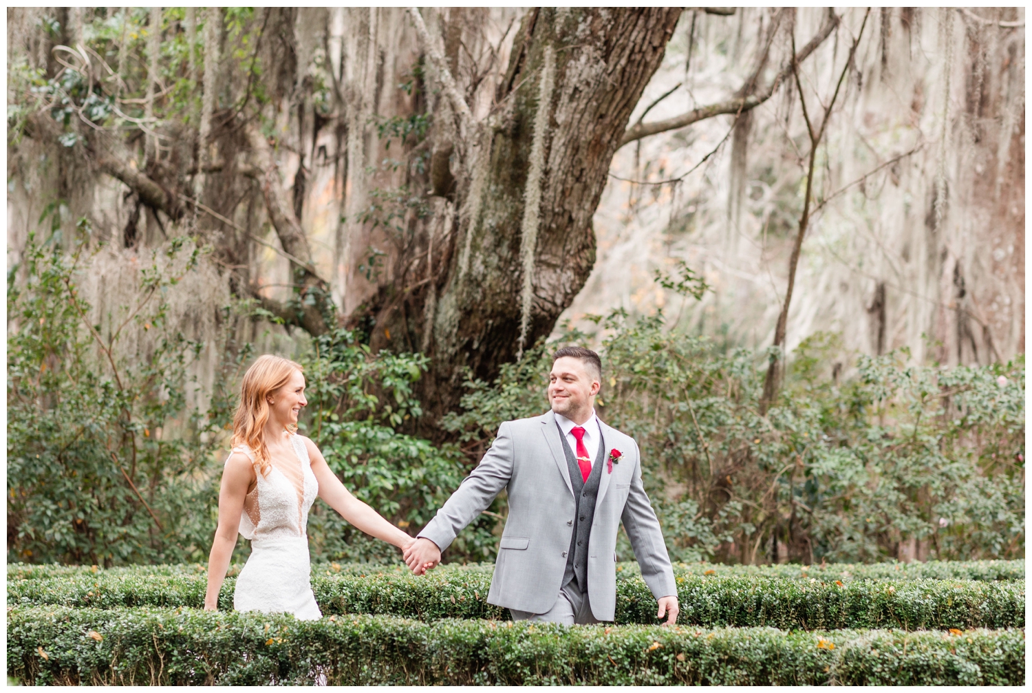 bride and groom walking under mossy trees during intimate Charleston winter elopement at Magnolia Plantation and Gardens