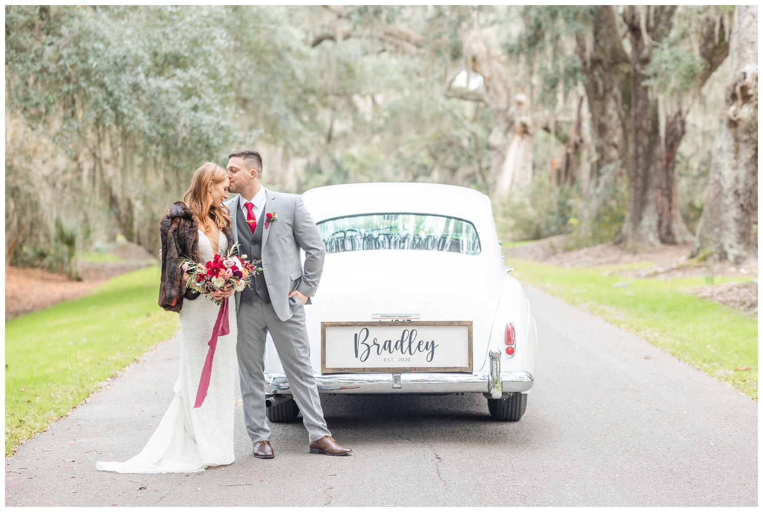 groom kissing bride by Rolls Royce for intimate Charleston winter elopement outside Magnolia Plantation and Gardens