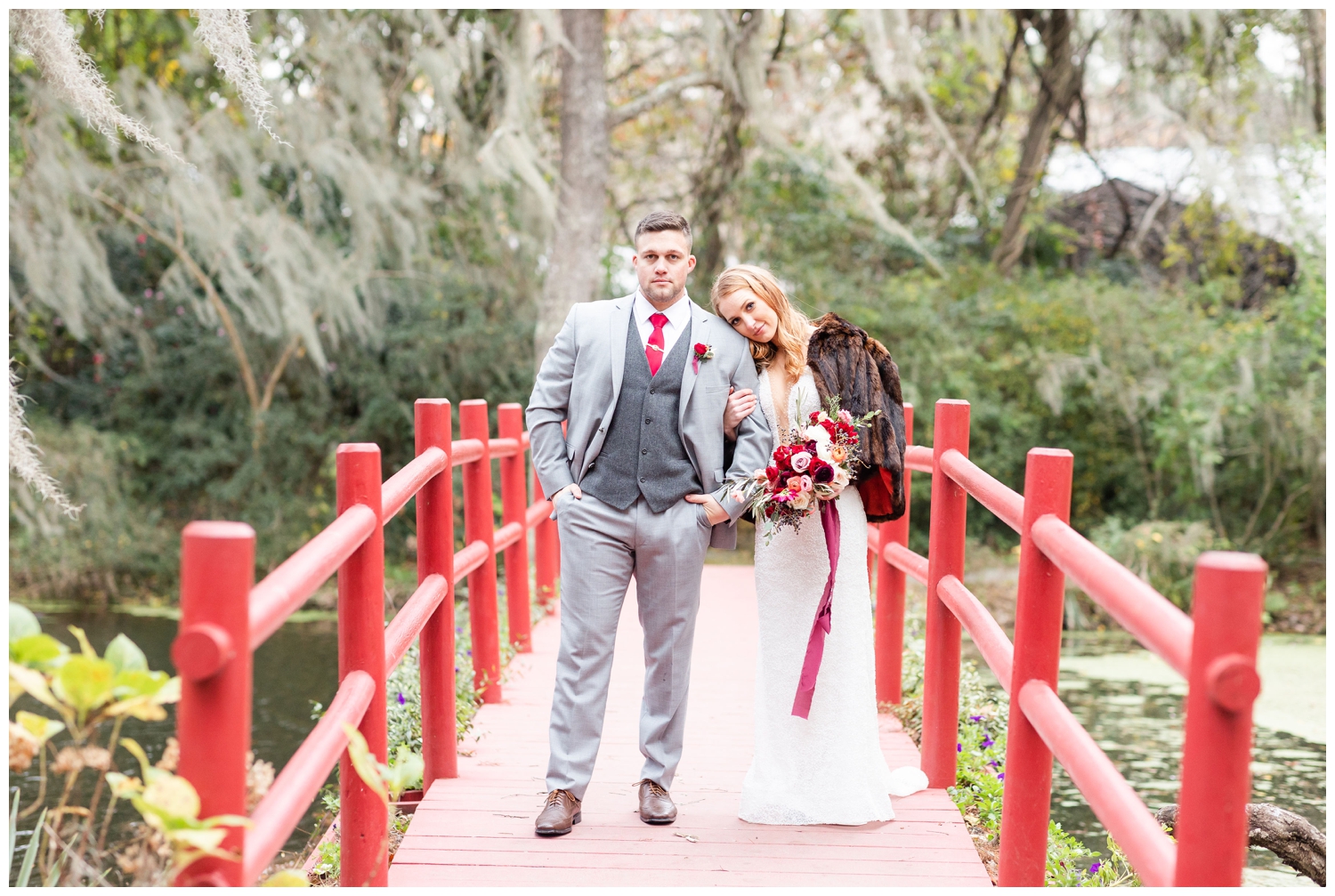 bride and groom standing on red bridge at Magnolia Plantation and Gardens