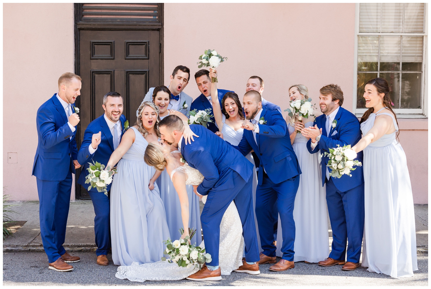 bridal party cheering with bride and groom kissing The Cedar Room Charleston wedding