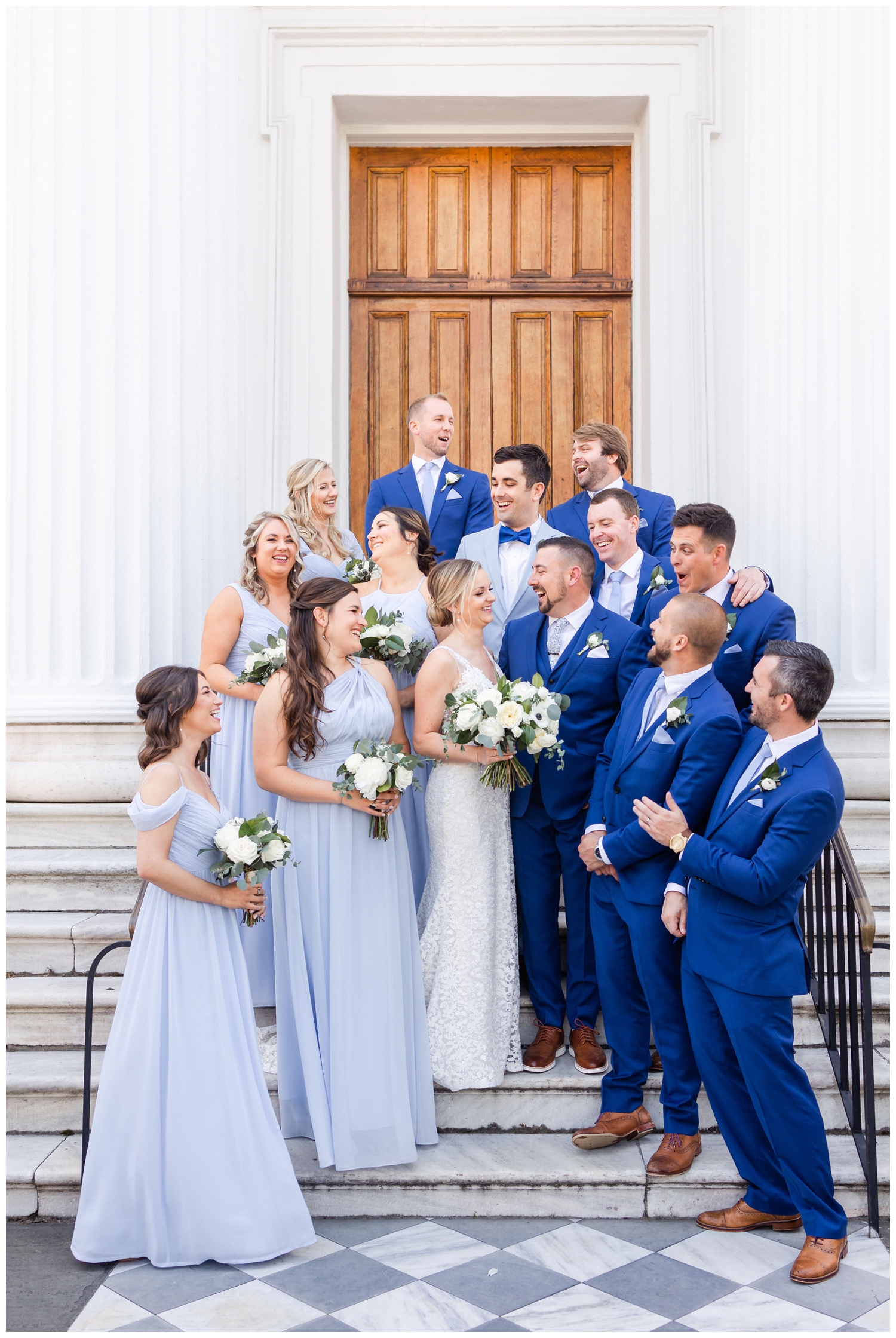 bridal party portait blue dresses and blue tux on steps in Charleston
