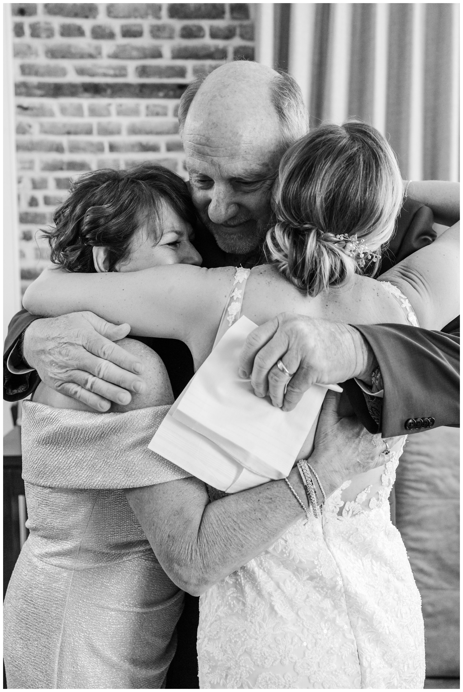 black and white photo of bride hugging parrents