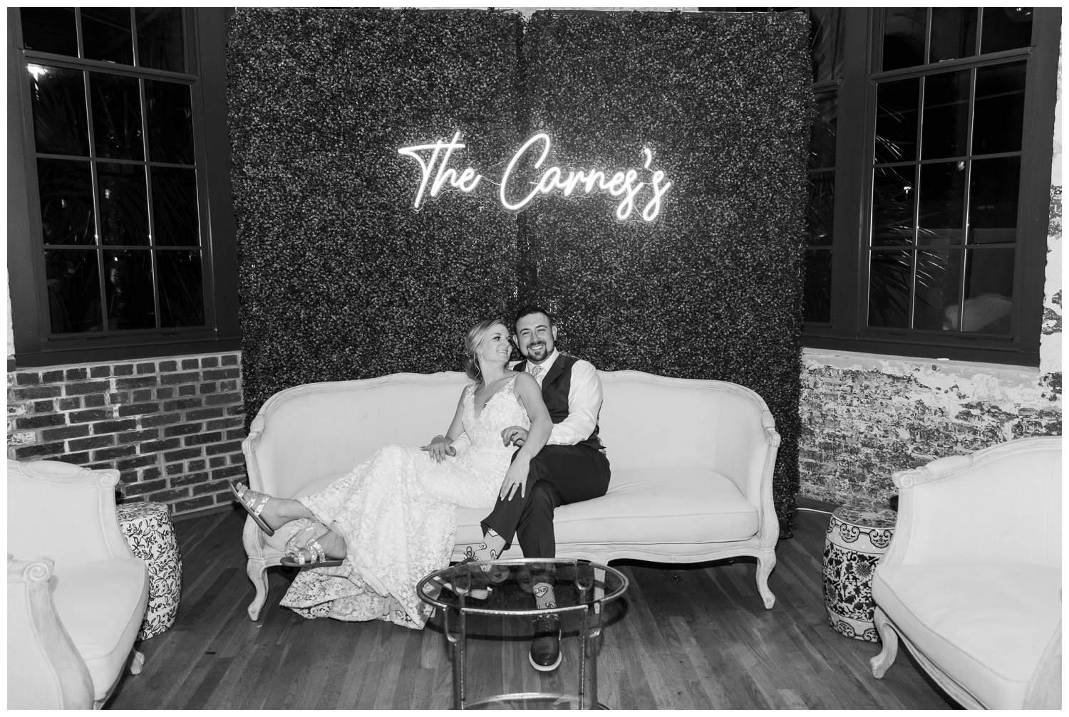 bride and groom sitting on couch inside The Cedar Room Charleston Wedding