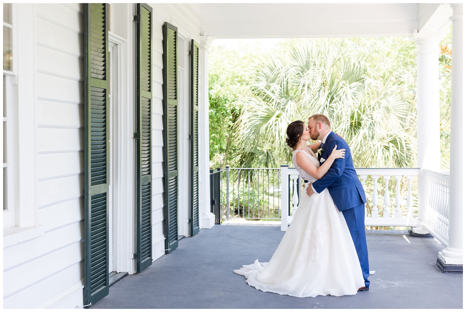 bride and groom kissing on the porch at spring Lowndes Grove wedding