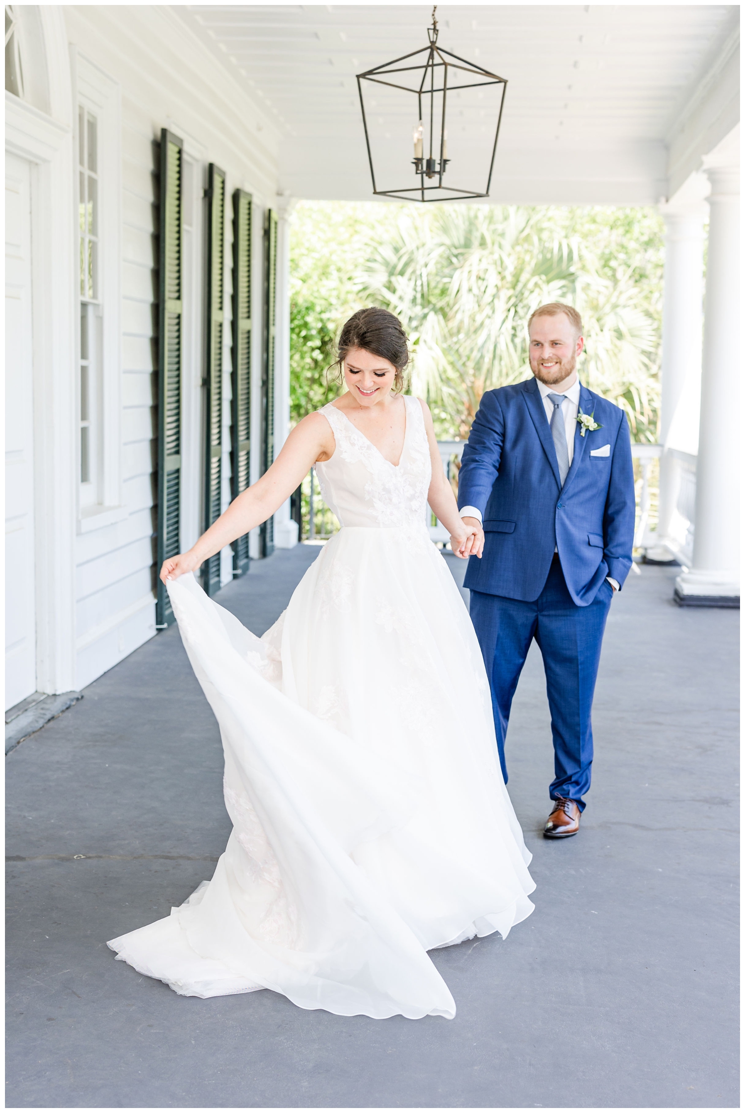 bride twirling dress holding groom's hand on porch at Lowndes Grove
