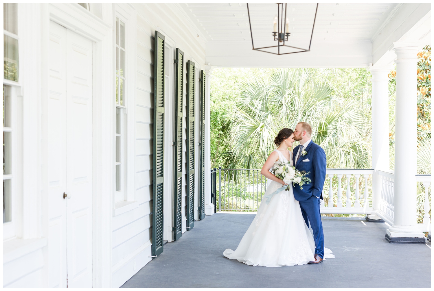bride and groom kissing underneath the Lowndes Grove porch