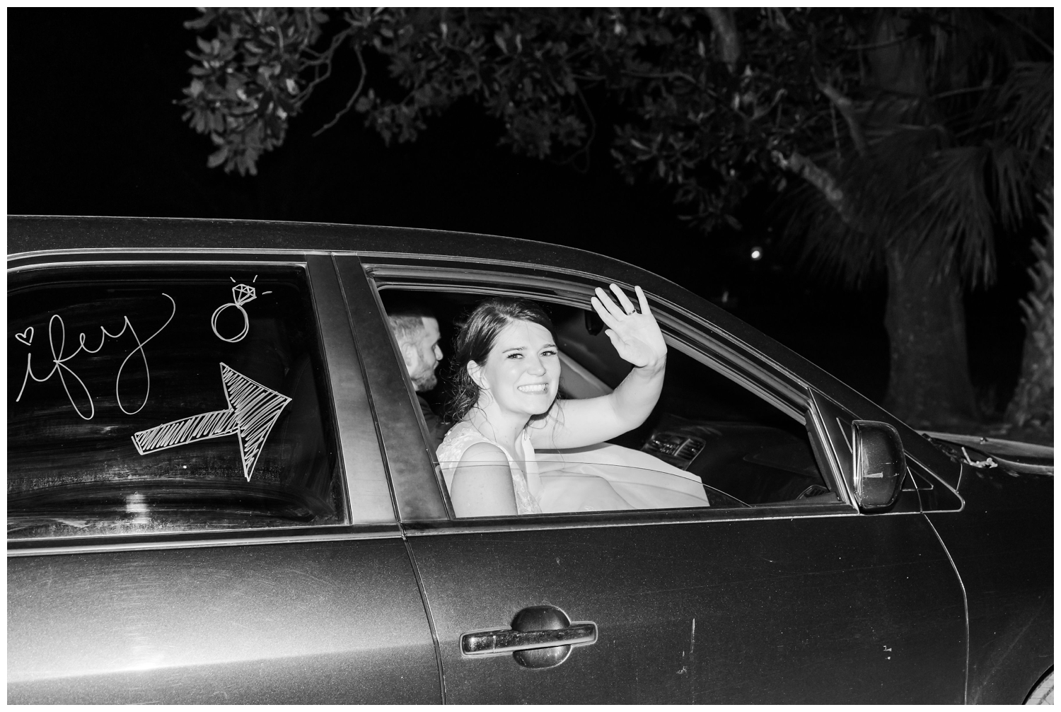 bride waving goodbye in get away car
