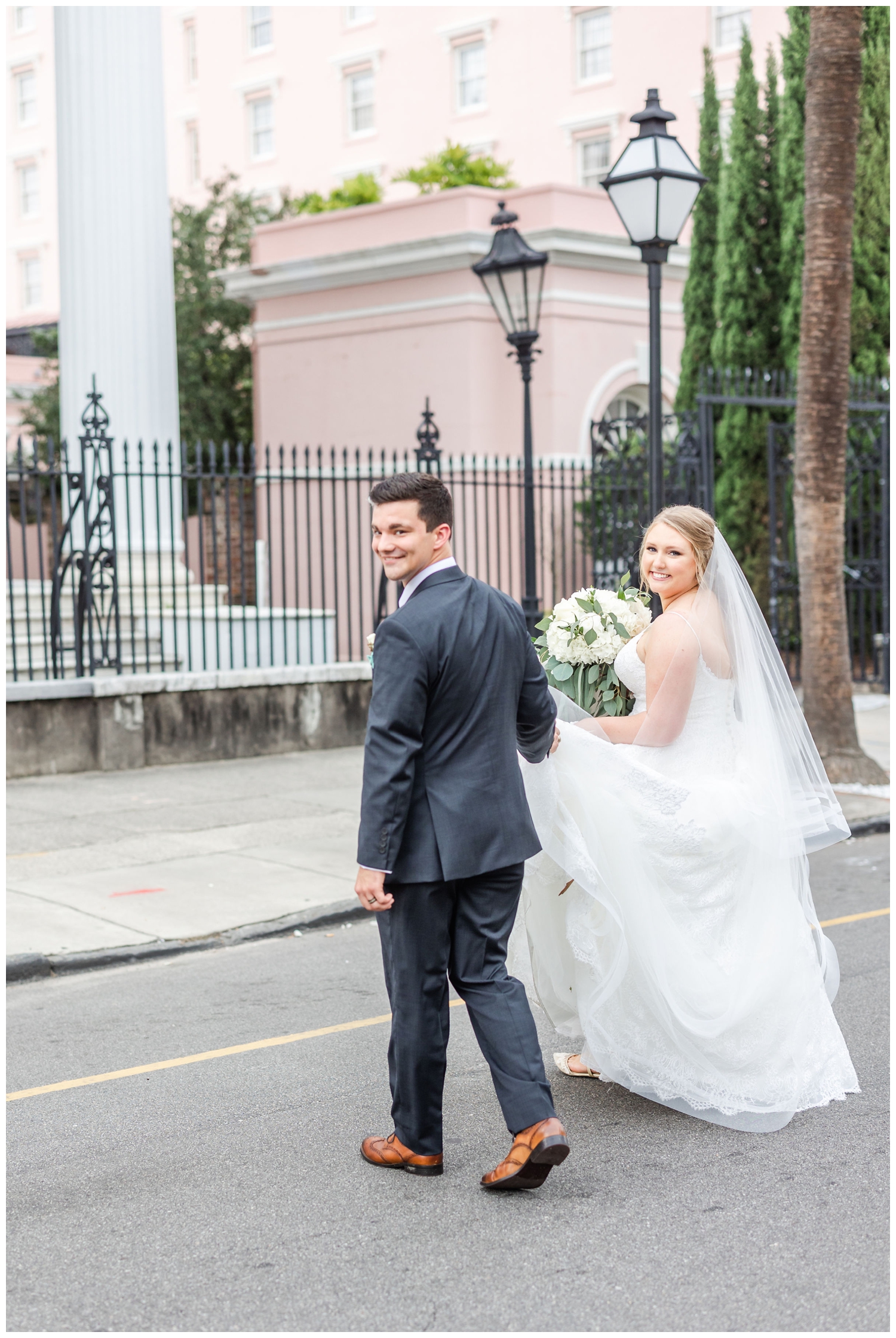 newlyweds walking in street by Charleston Merchants Hall Reception