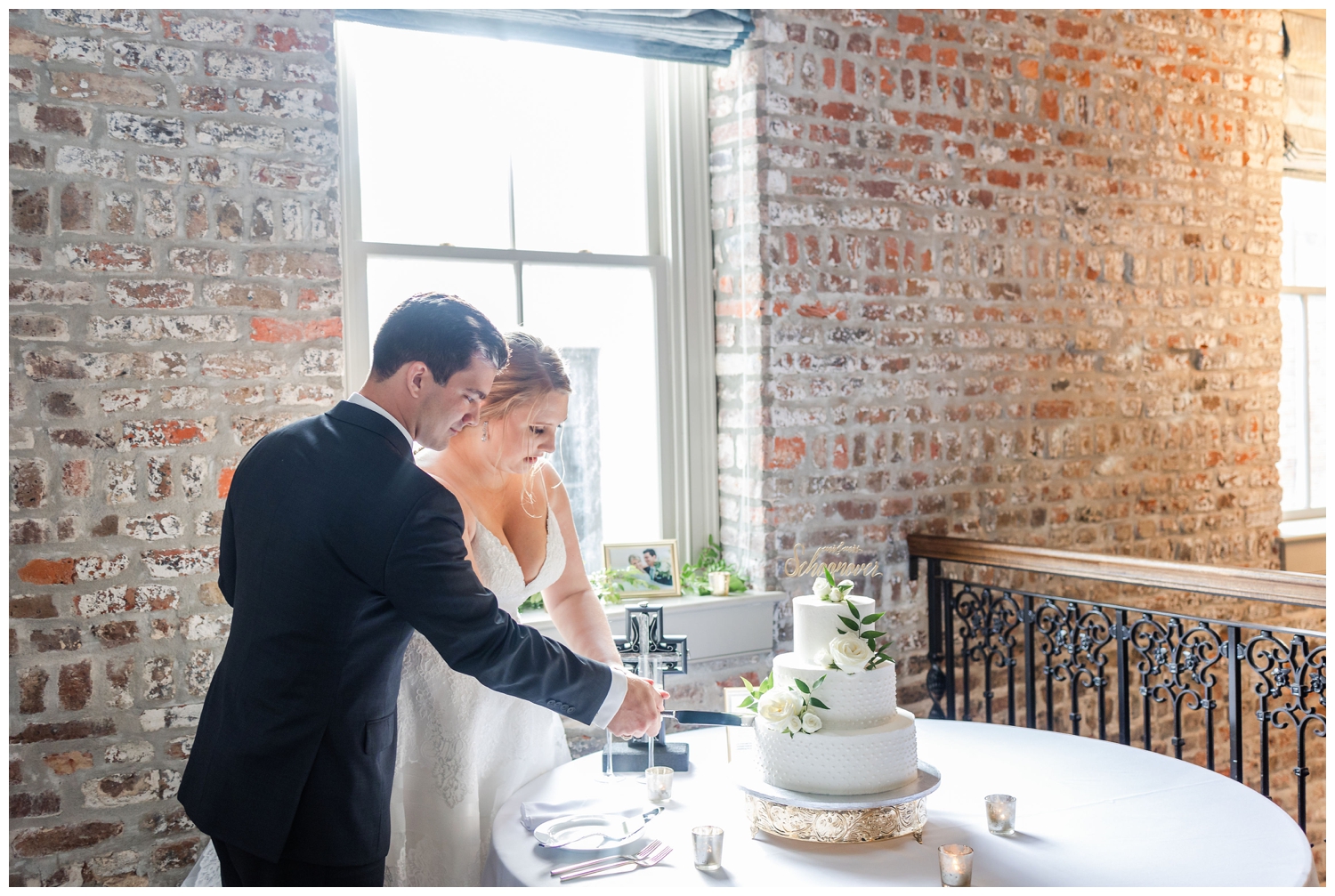 cake cutting by bride and groom inside Charleston Merchants Hall Reception