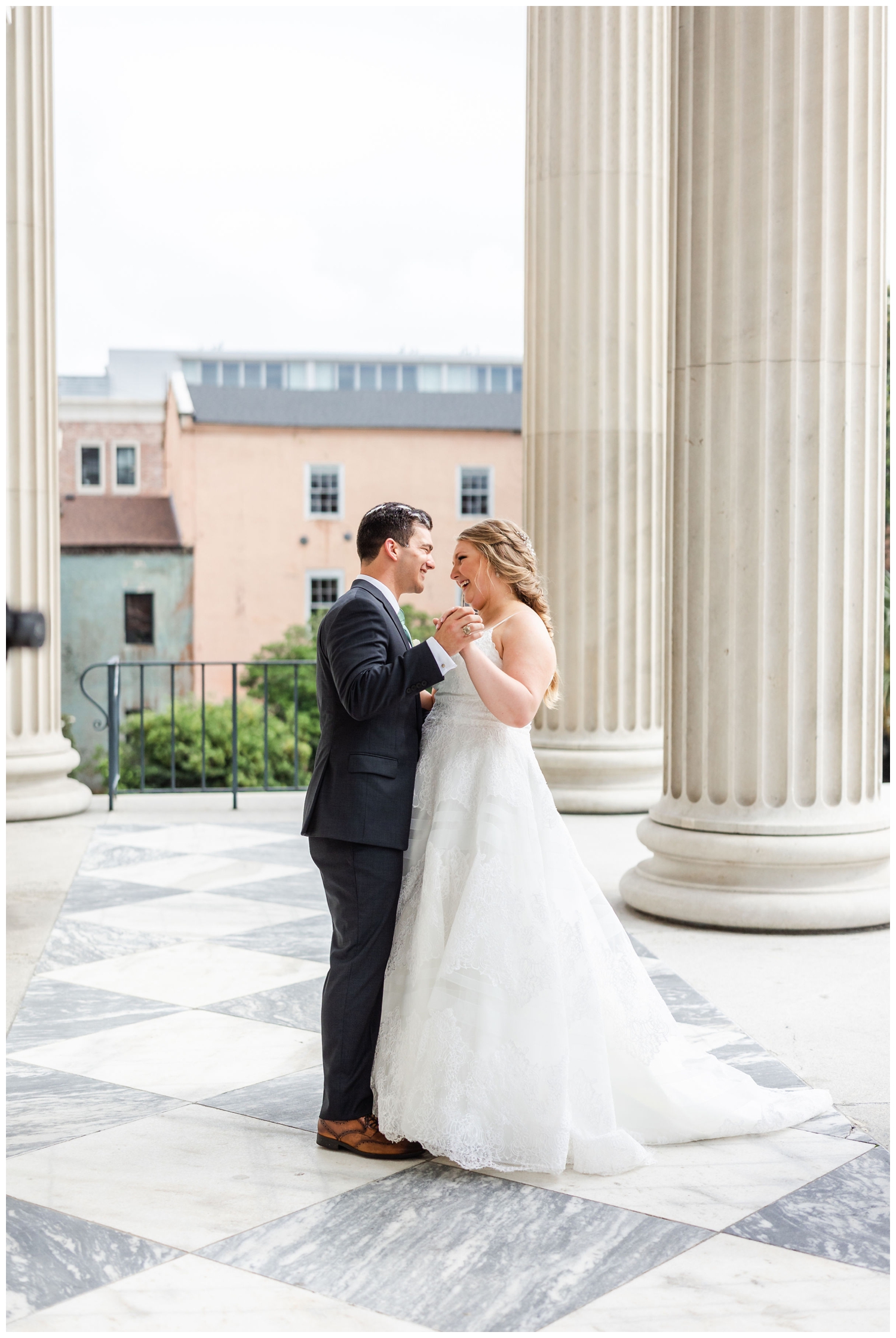 newlyweds dancing outside by columns at Charleston Merchants Hall