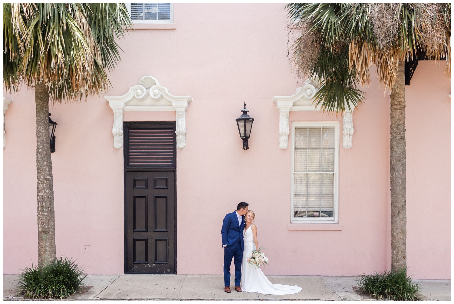 bride and groom standing by pink wall for southern summer wedding Charleston