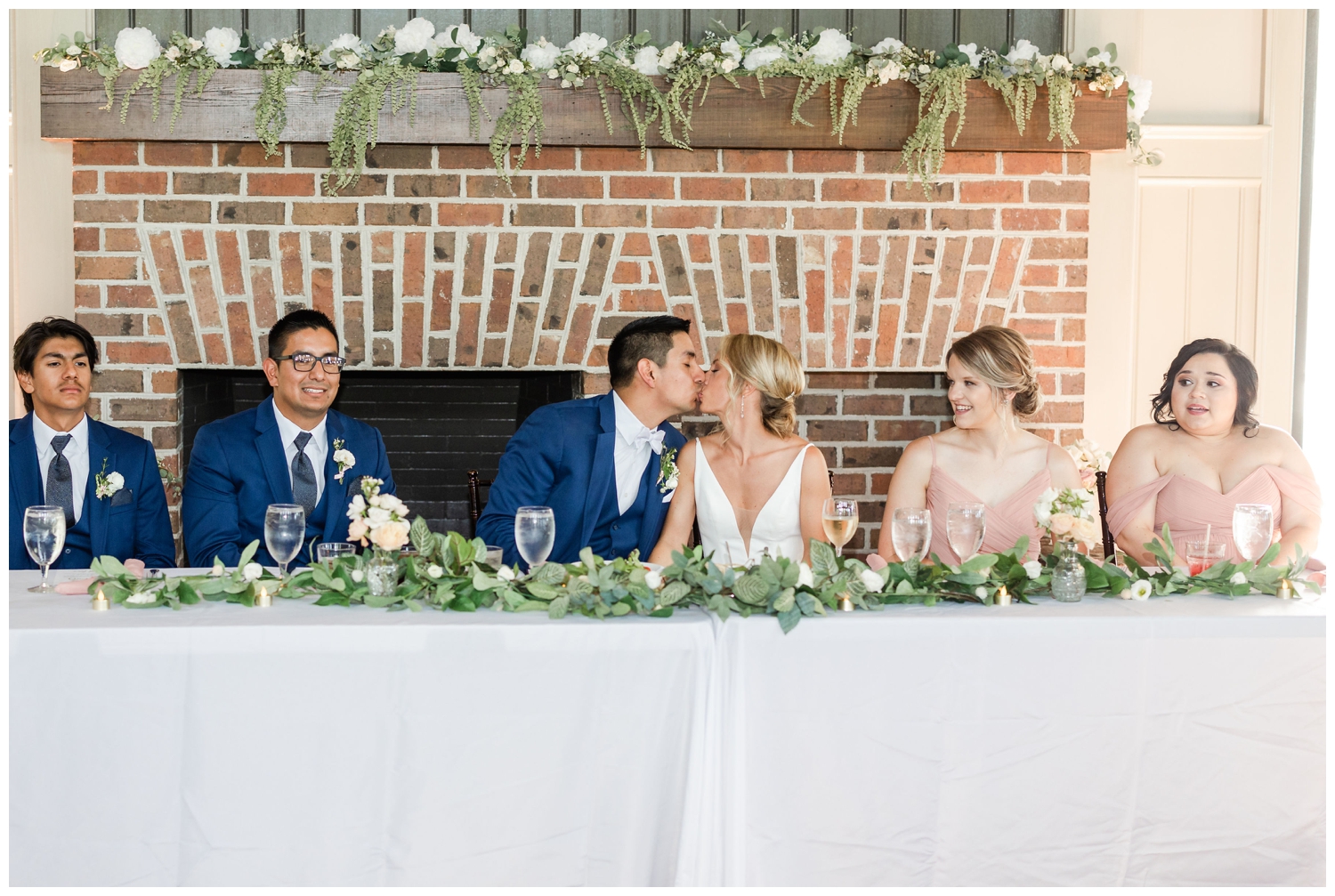 bride and groom kissing at sweetheart table for southern summer wedding Charleston
