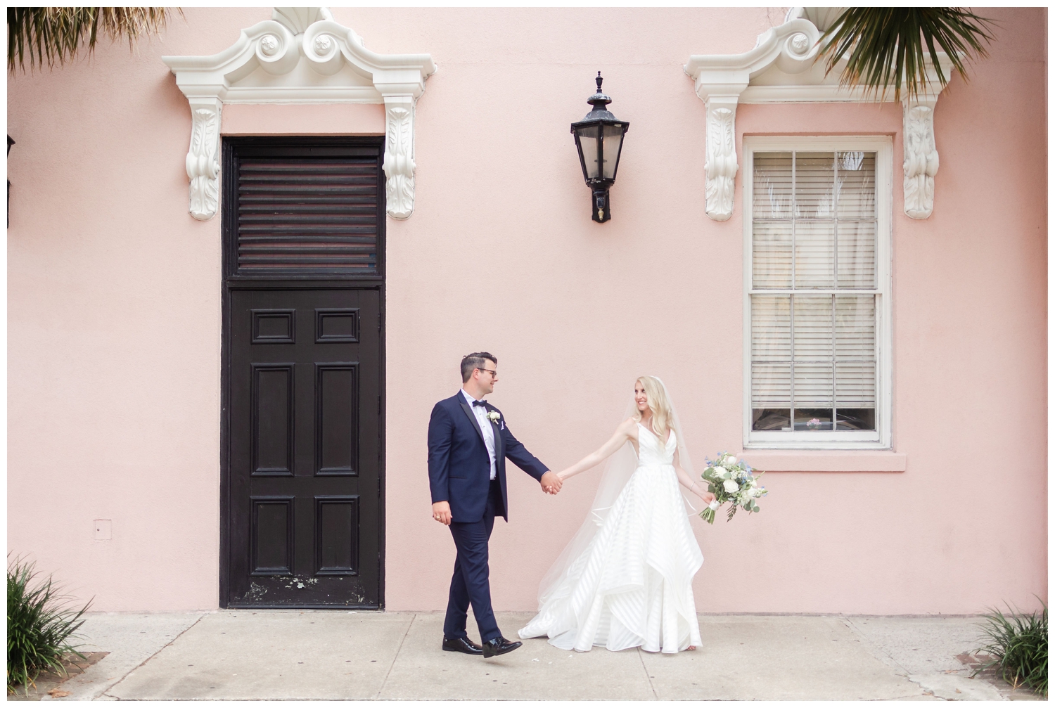 bride and groom holding hands walking in front of the Mills House in Charleston luxury Cedar Room wedding