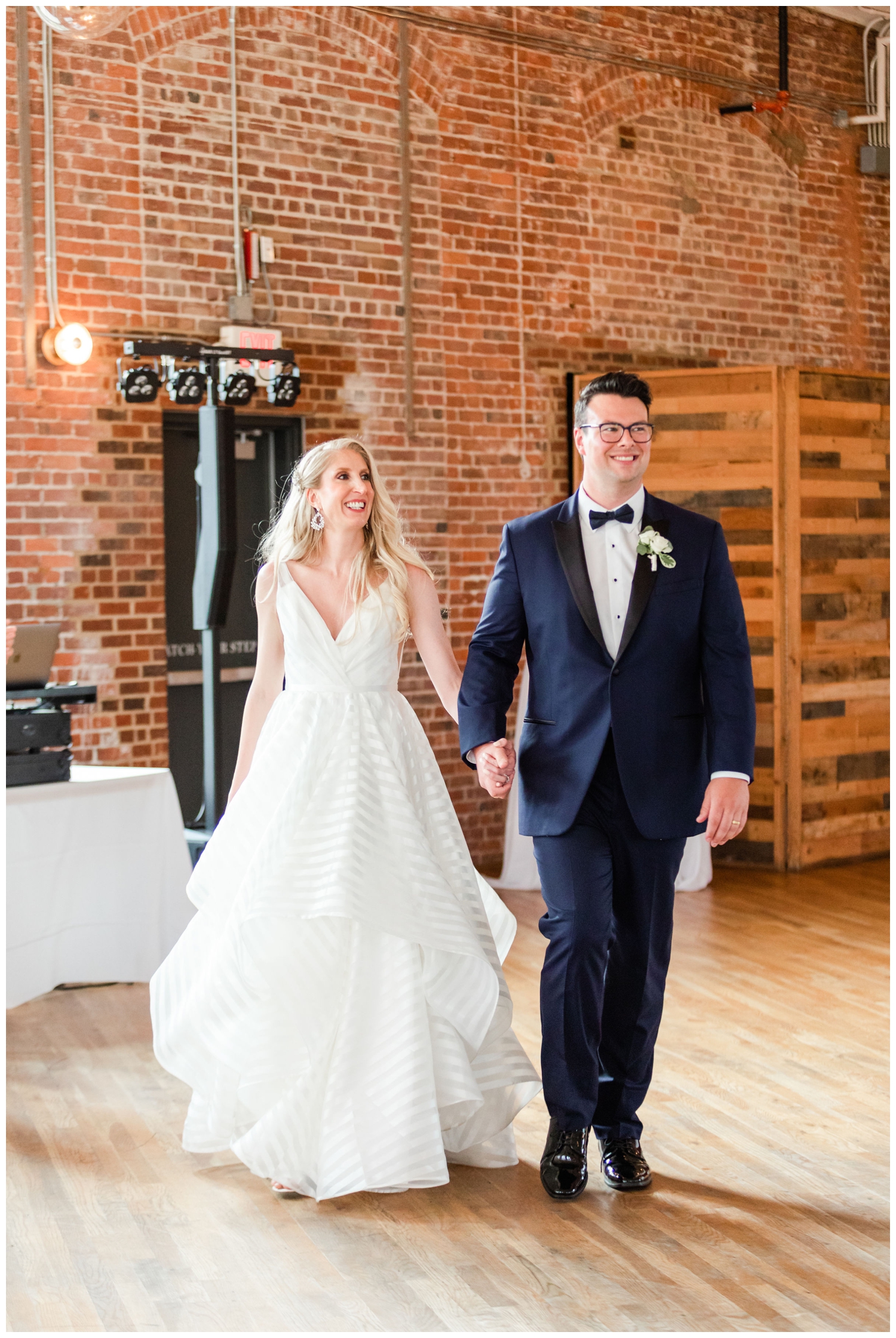 bride and groom entering luxury Cedar Room wedding reception