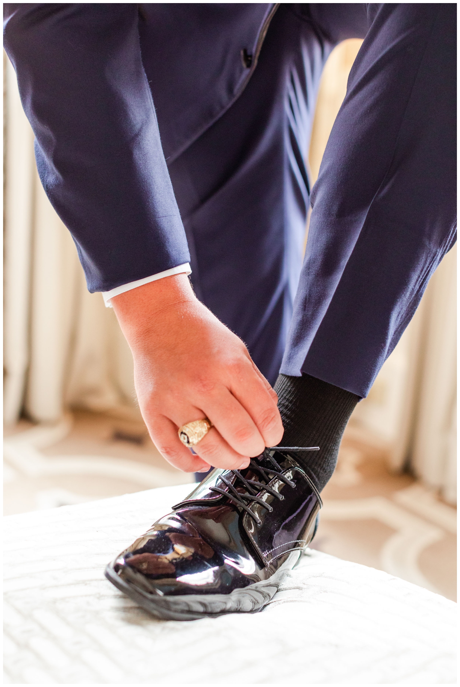groom putting on black shoe for luxury Cedar Room wedding