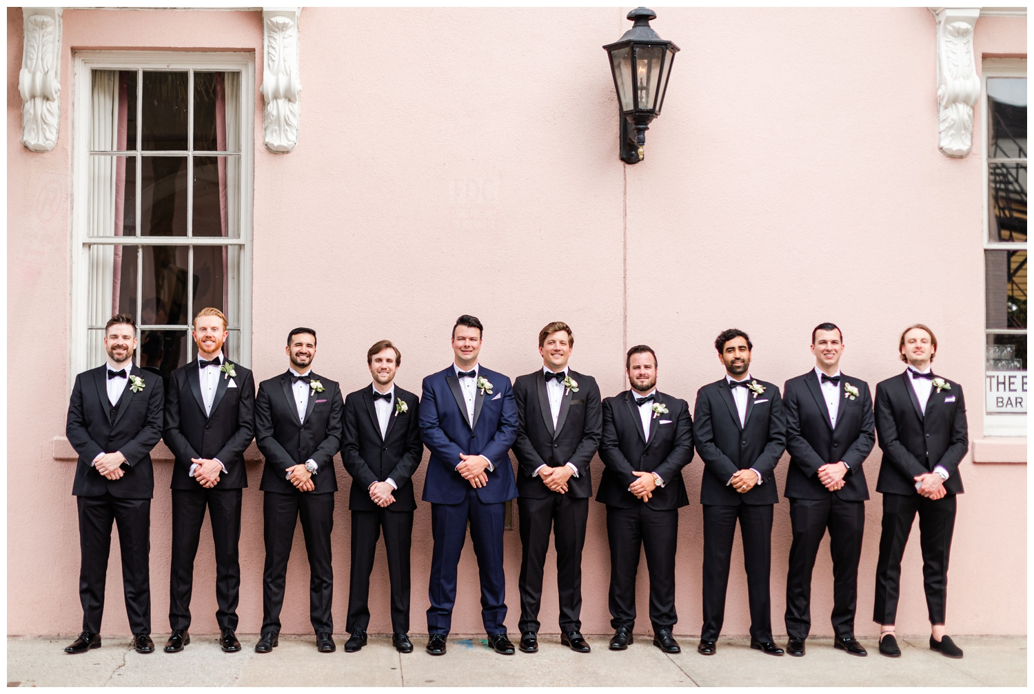 groom and groomsmen standing in front of Mills House for luxury Cedar Room wedding