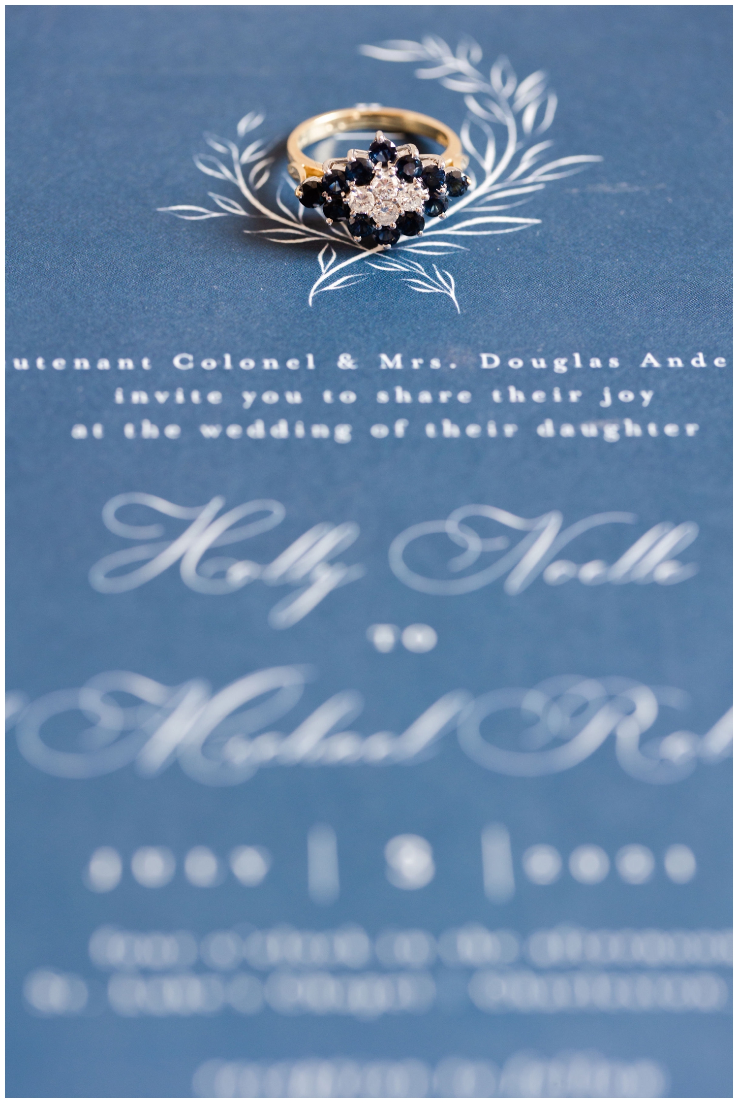 sapphire wedding ring on blue invitation suite